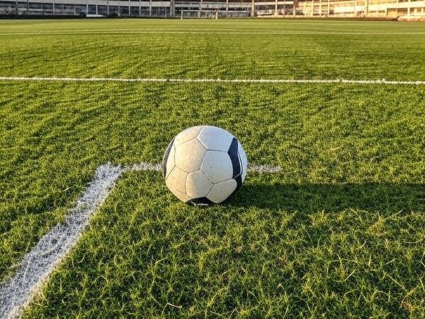 Campo de futebol em Goiânia com bola solitária, representando individualidade no esporte pelo Atlético-GO.