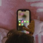 Criança mexendo no celular com as redes sociais visíveis no aparelho. — Foto: Unsplash/Sanket Mishra