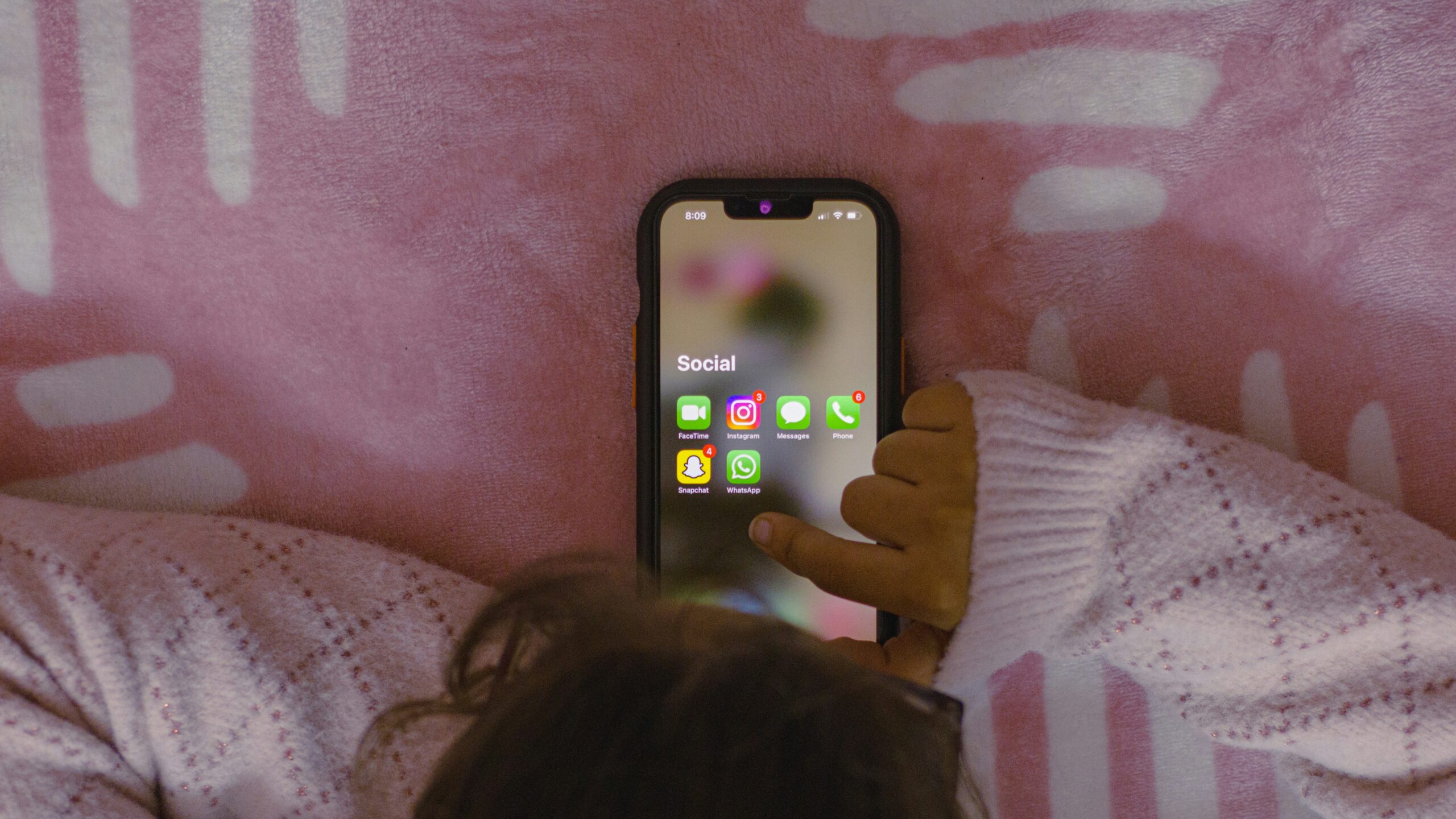 Criança mexendo no celular com as redes sociais visíveis no aparelho. — Foto: Unsplash/Sanket Mishra